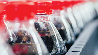 Soda pop bottles on a manufacturing line at a bottling plant where flexible manufacturing can improve efficiency.